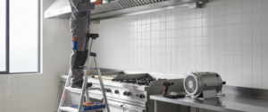 Commercial kitchen exhaust fan replacement sydney — Technician completing a commercial kitchen exhaust fan replacement at a Sydney restaurant for King Fabrication